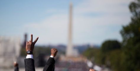 People put their hands in the air during a rally to mark the 20th anniversary of the Million Man March, on Capitol Hill, on Saturday, Oct. 10, 2015, in Washington. Waving flags, carrying signs and listening to speeches and songs, the crowd gathered at the U.S. Capitol and spread down the Mall under on a sunny and breezy fall day. (AP Photo/Evan Vucci)